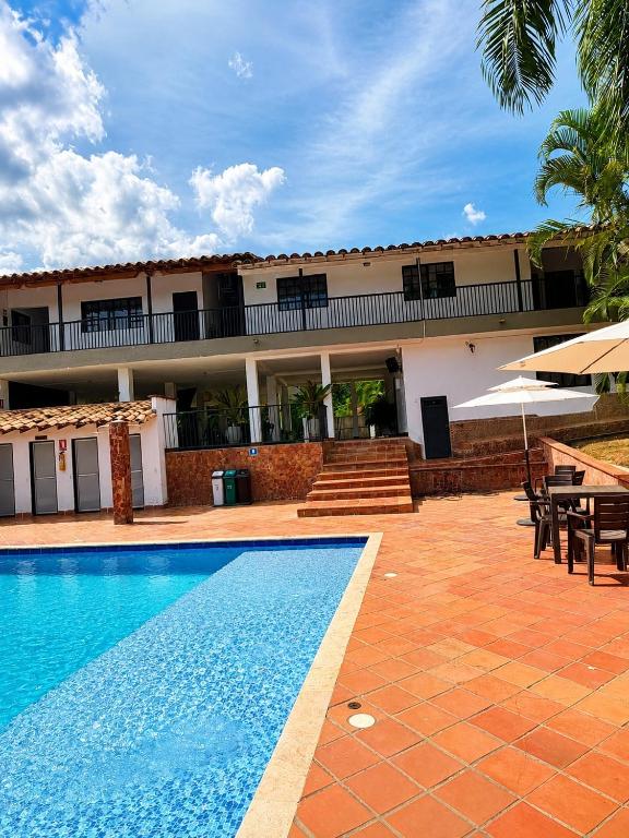 a hotel with a swimming pool in front of a building at Finca Hotel Villa Alba in San Jerónimo