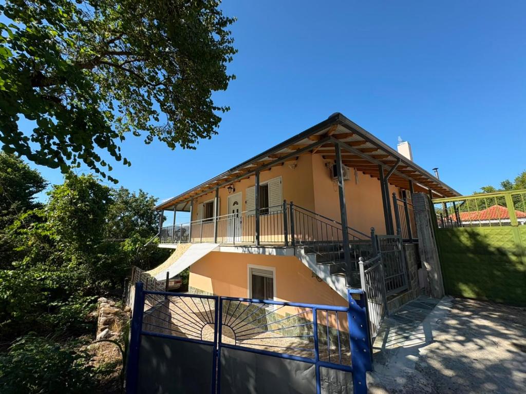a house with a balcony and a fence at Mountain House Përmet 