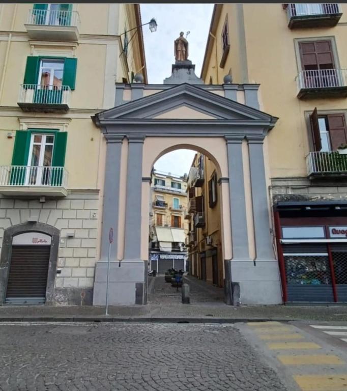 a building with an arch in the middle of a street at Ciemme Apartments in Castellammare di Stabia