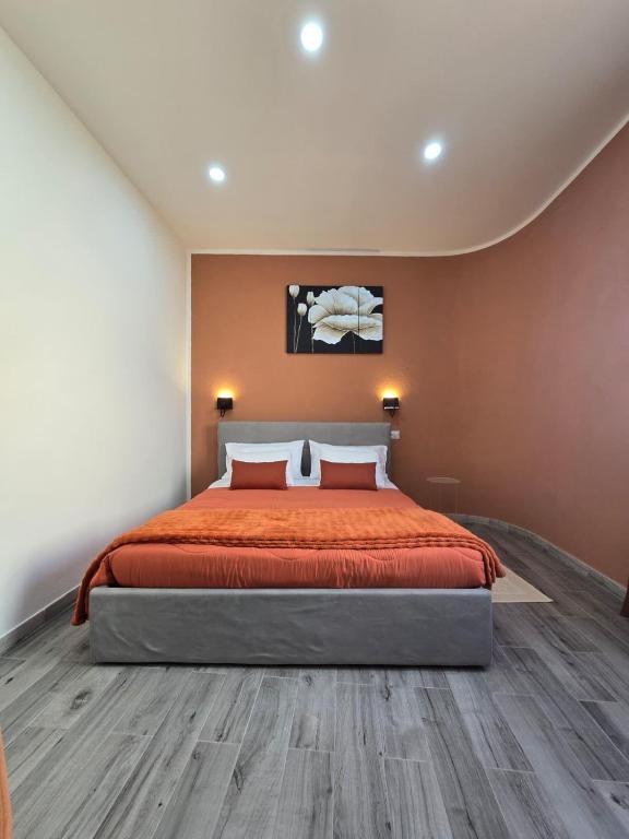 a bedroom with a large bed with orange bedspread at Isabel House in Capoterra