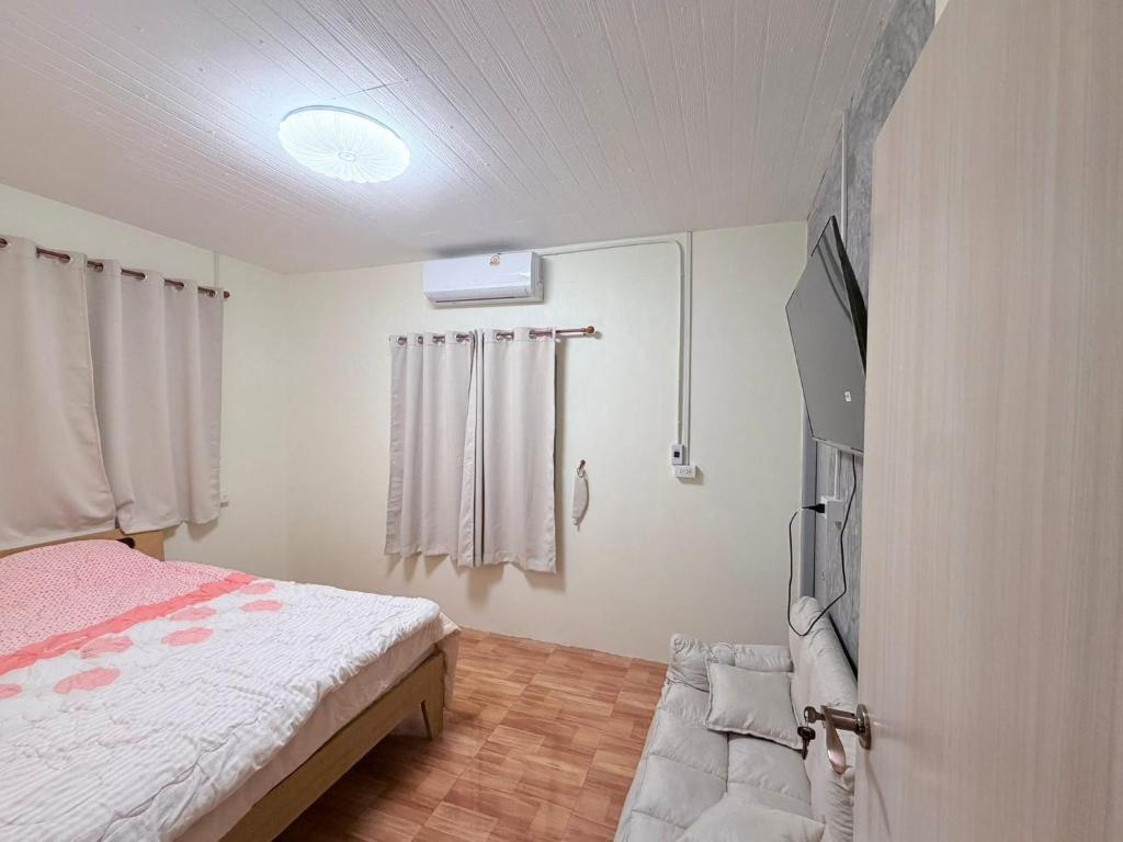 a bedroom with a bed and a flat screen tv at PATTARAWAN House in Thong Sala