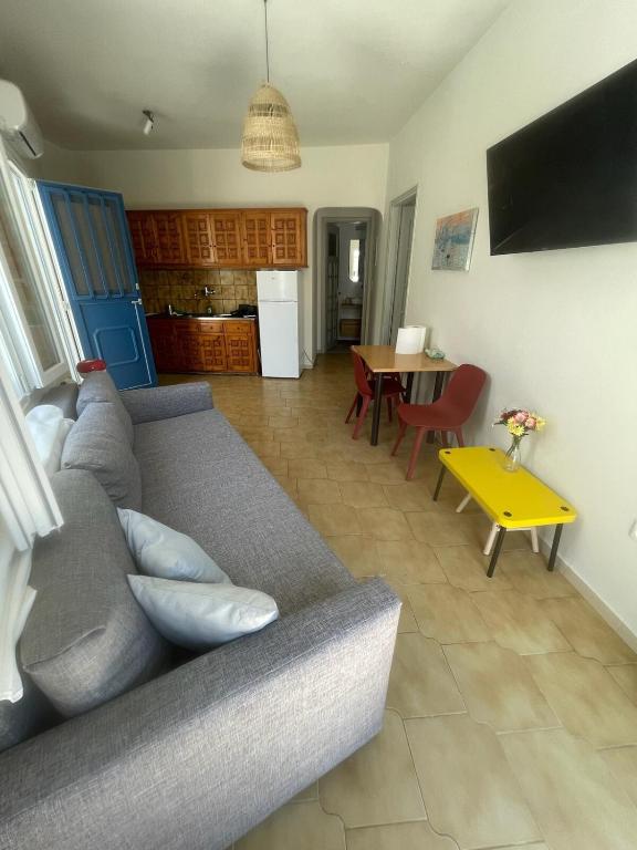 a living room with a gray couch and a table at Blue Door Hideaway in Moutsoúna