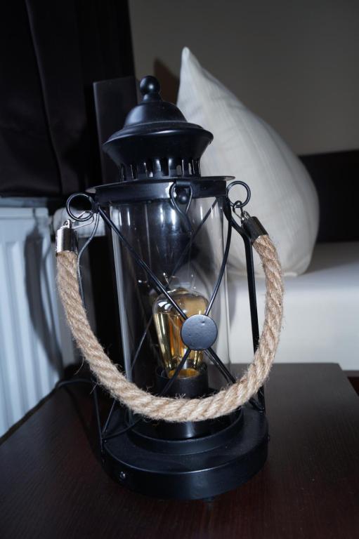 a black lantern with a rope around it on a table at MY-BED Hamburg in Hamburg