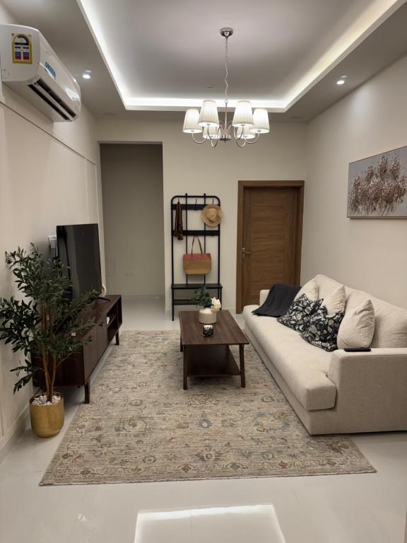 a living room with a couch and a table at Luxury Cozy 2BR Penthouse in Ḩayl Āl ‘Umayr