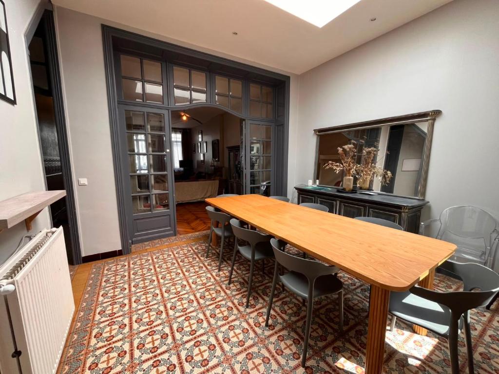 a dining room with a wooden table and chairs at Charme et confort - Maison Roubaix 5 chambres in Roubaix