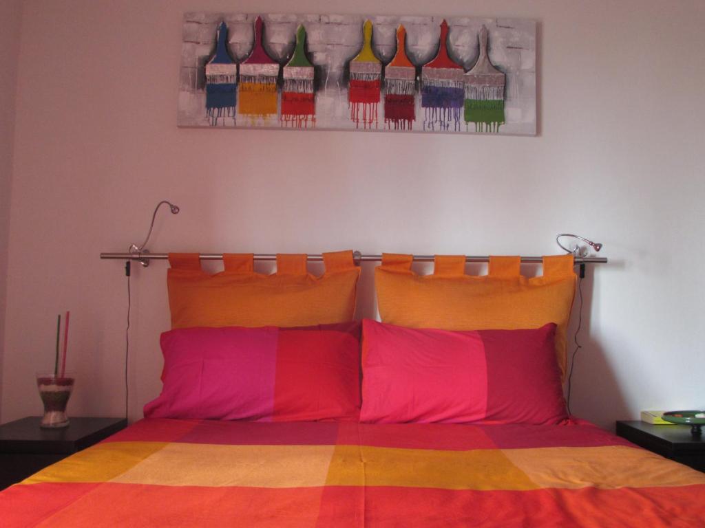 ポルト・エンペードクレにあるB&B Ohanaのベッドルーム1室(カラフルな枕付きのベッド1台付)