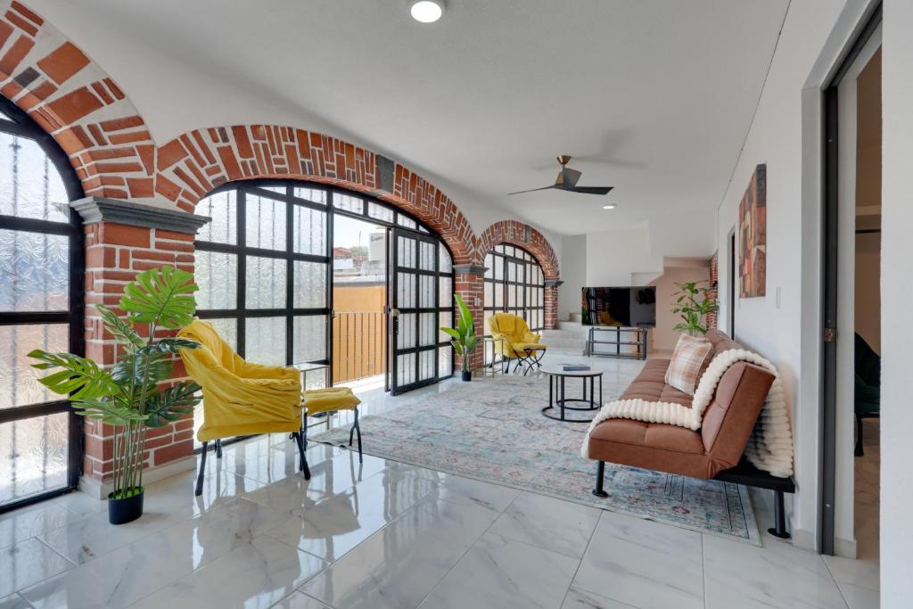 un soggiorno con sedie e un muro di mattoni di Stylish & Spacious Unit w/ Deck in Cuernavaca a Cuernavaca