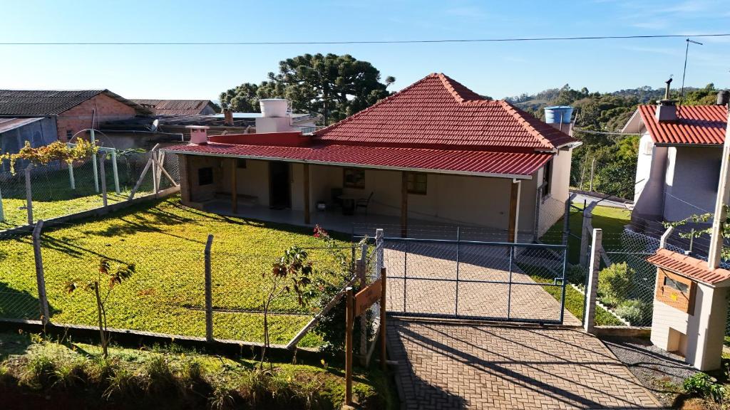 a house with a fence in front of a yard at Casa Nona Chema in Bento Gonçalves