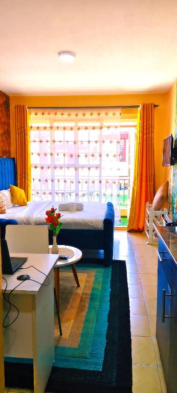 a bedroom with a bed and a table in a room at Aheri Homes in Ruaka