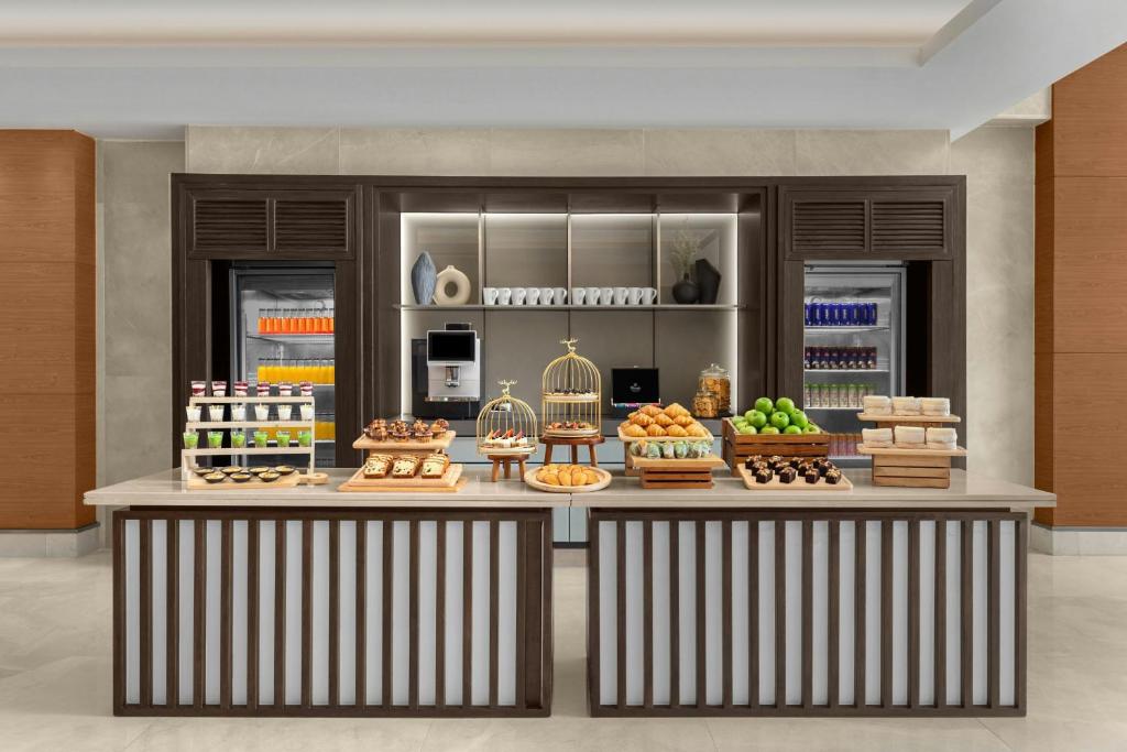 A generously presented breakfast counter with pastries, fruit, drinks and coffee service.