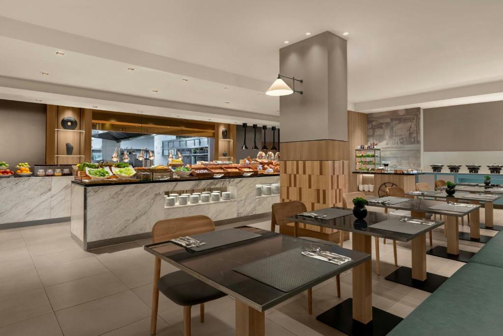 A buffet counter displays pastries, fruit, and other breakfast dishes beside the dining area.
