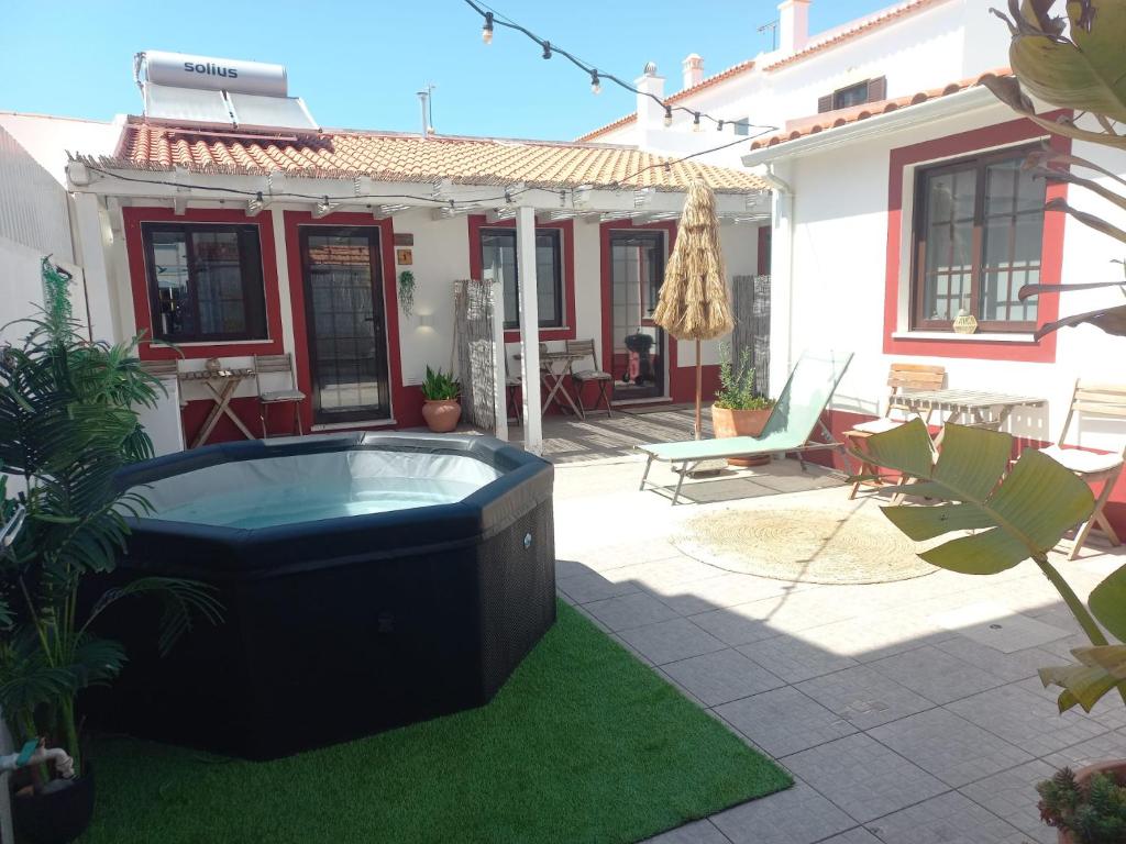 a backyard with a hot tub in the yard at Brisa de Milfontes in Vila Nova de Milfontes