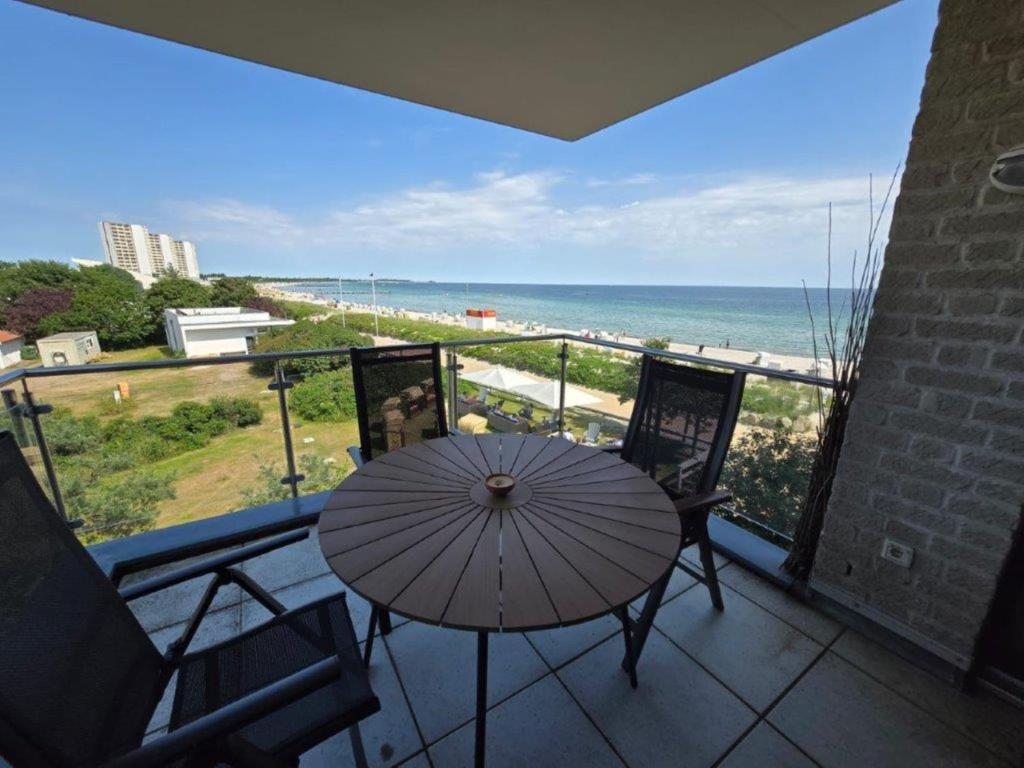 a balcony with a table and chairs and a view of the beach at Fehmarn- Ostseeferien FeWo Prusseit 171 in Fehmarn