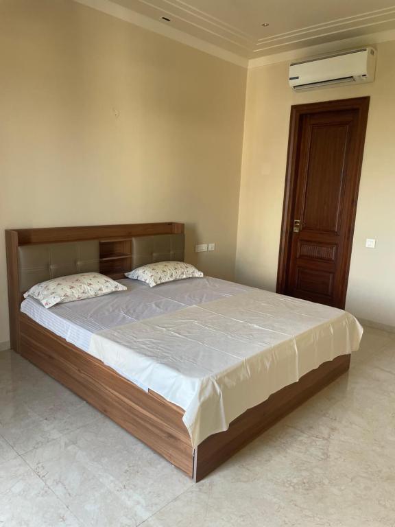 a bedroom with a large bed with a wooden headboard at Luxury Executive Homestay in Jāmb