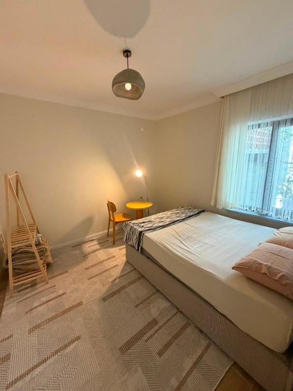 a bedroom with a bed and a table and a window at Go to Sleep in Gelibolu