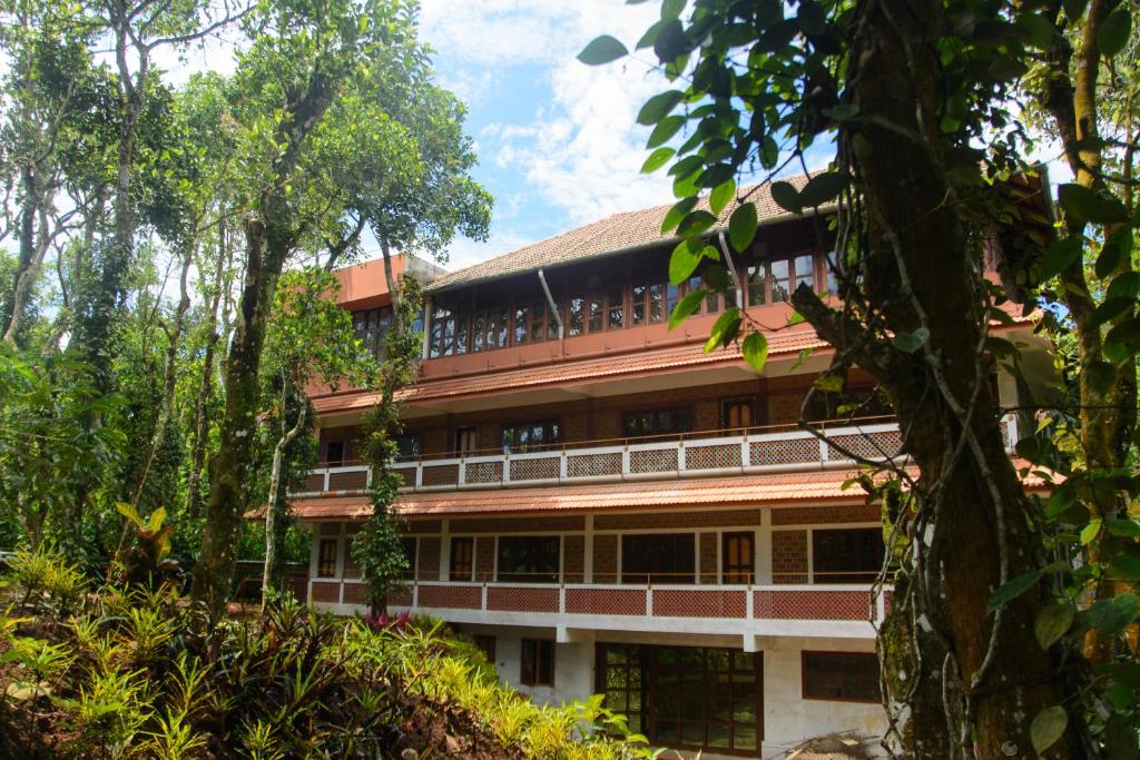 a building in the middle of a forest at BASIS Mountain House in Thekkady
