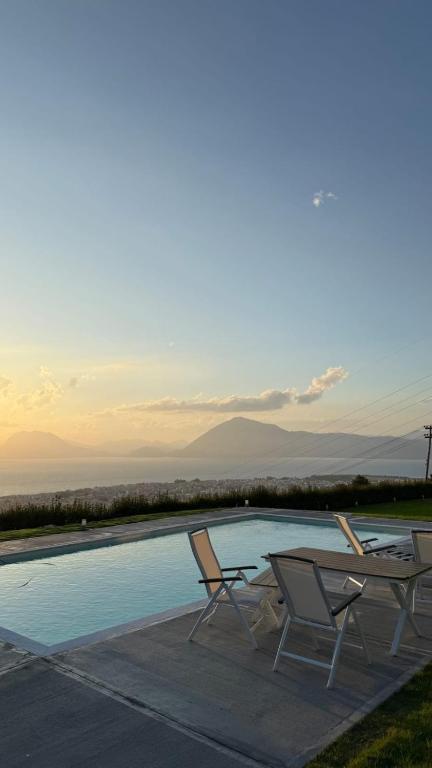 two chairs and a swimming pool with a view at Boomerang Villa in Patra