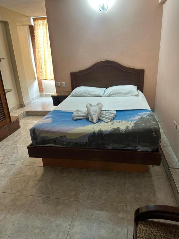 a bedroom with a bed with two towels on it at Cid Hotel Mérida in Mérida