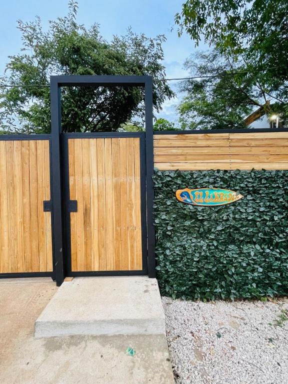 a wooden gate with a cross in front of a fence at Apartamentos El Labrador in Tamarindo