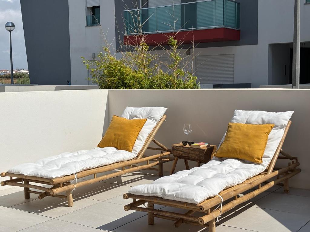 two chairs with pillows sitting on a balcony at Alto Mar Apartment 2 in Atouguia da Baleia