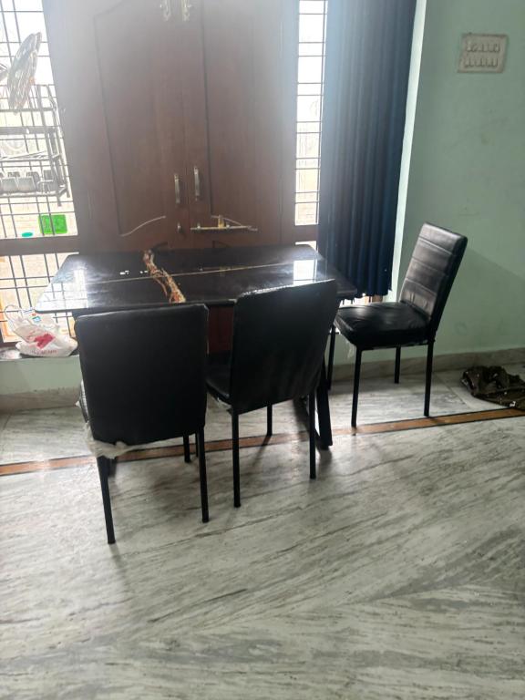 a dining room with a table and two chairs at Lara Homestay duplex 1bhk in Secunderabad