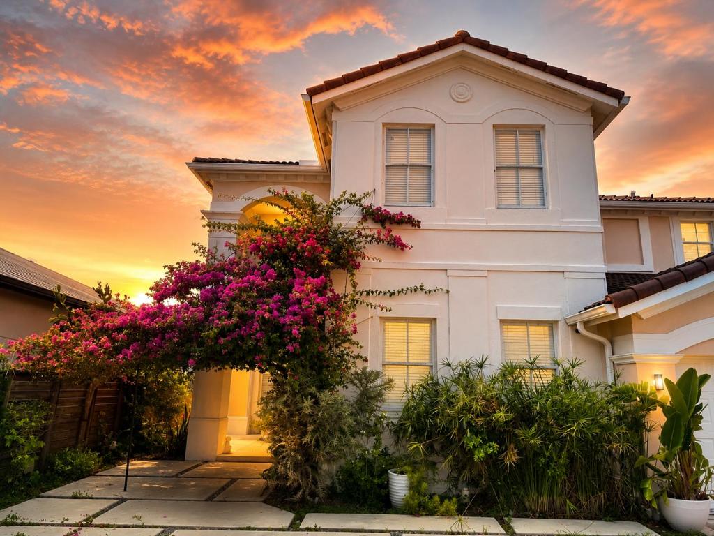 a white house with flowers in front of it at The Garden, Miami Lakes in Miami Lakes