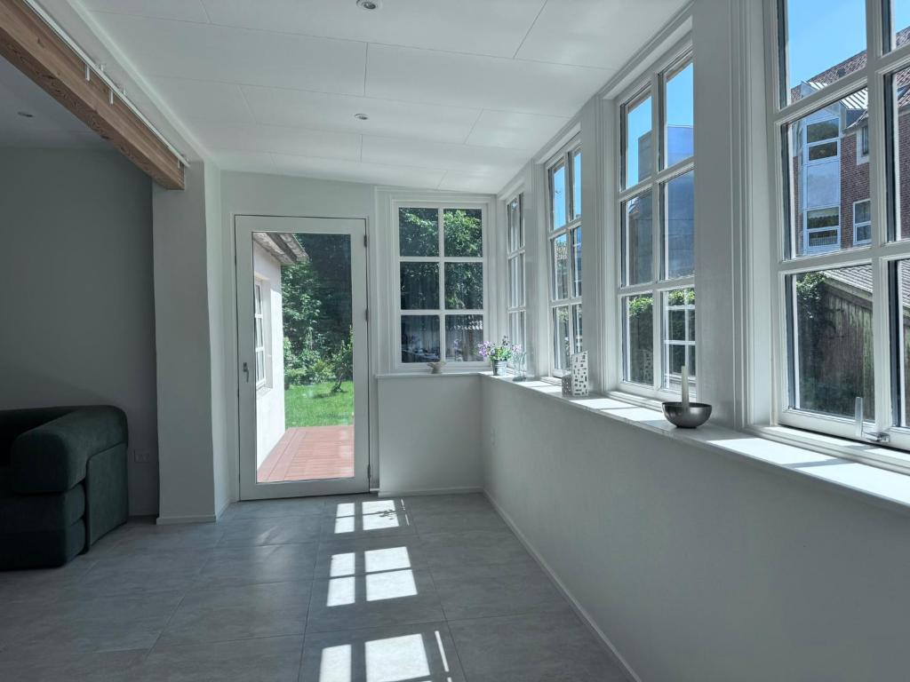 an empty living room with windows and a couch at Tønder Byhus in Tønder