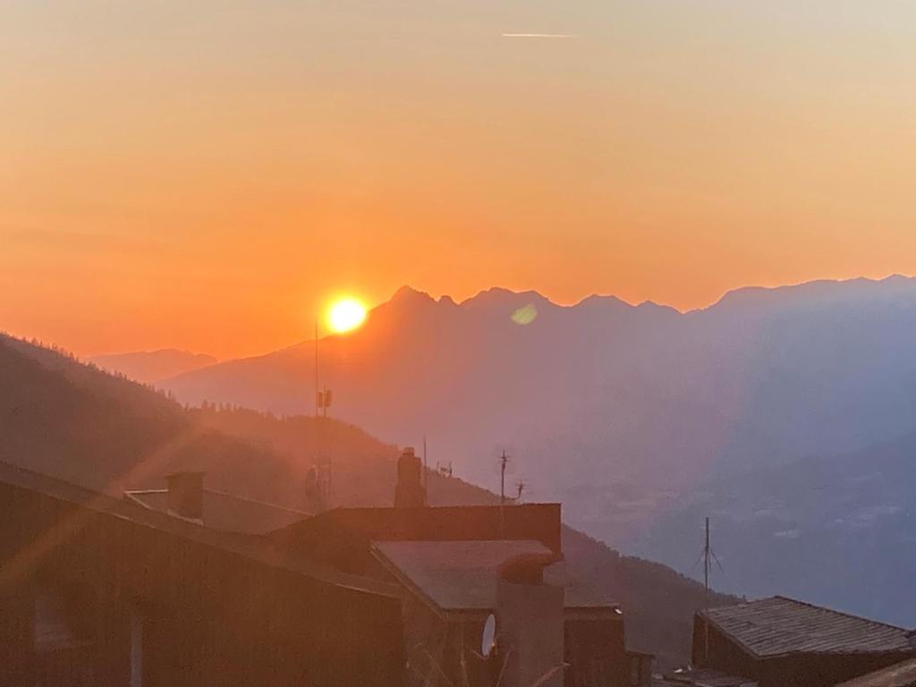 a sunset over a city with mountains in the background at Orrianes 1650 in Les Orres