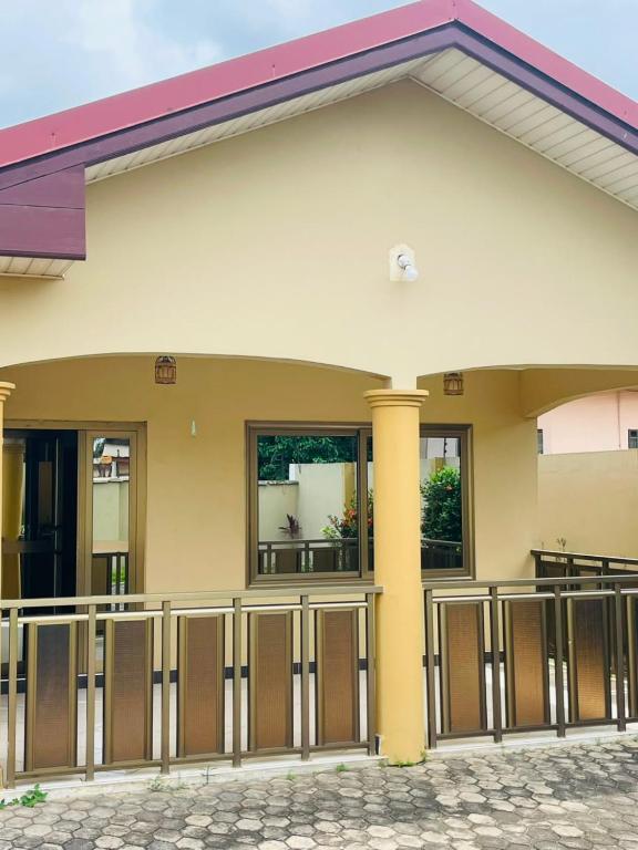 a building with a gate and a fence at Joyet Guest House in Amasaman