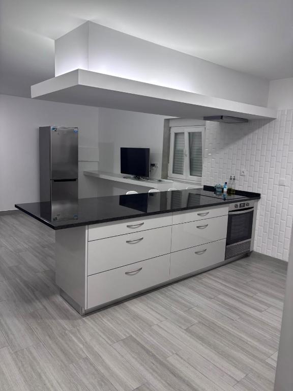 a kitchen with white cabinets and a black counter top at Casa Costa in Esmoriz