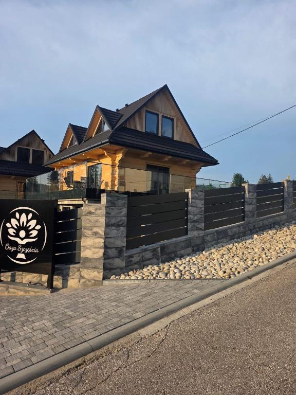 a house with a fence in front of it at Oaza Szczęścia in Koniaków