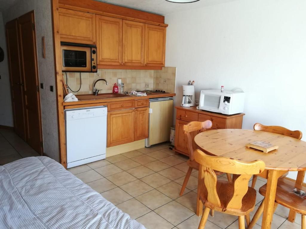 a kitchen with a wooden table and a kitchen with a table and chairs at Nice relax chalet ski m o d e r n in Arâches-la-Frasse