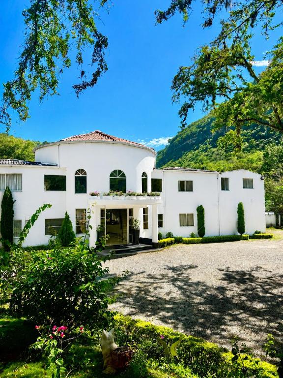 a large white house with a large driveway at Hotel Campestre Santa Catalina in San Gil
