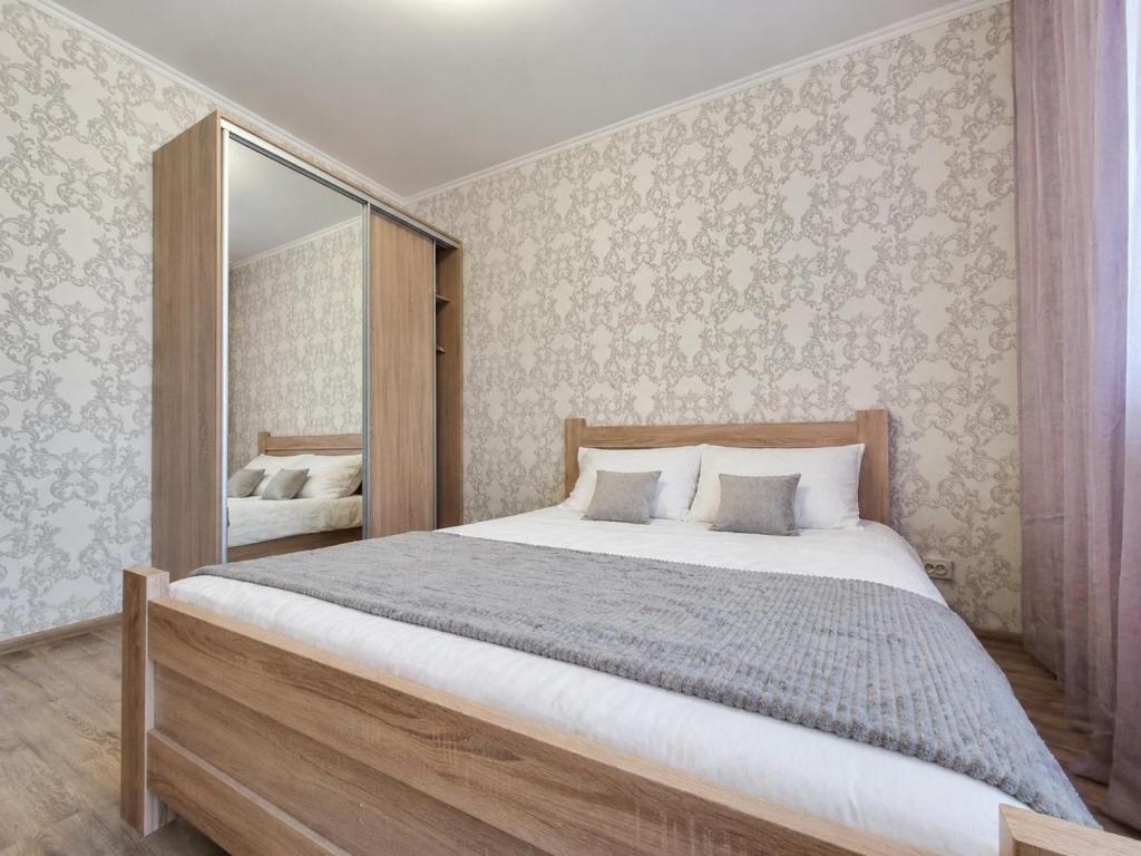 a bedroom with a large bed and a mirror at Панорамний Краєвид на Озеро Позняки Жк Лебединий in Kyiv