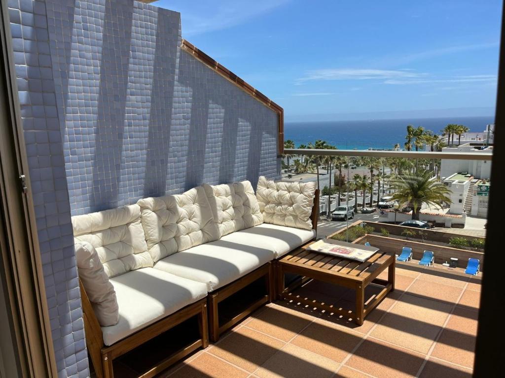 a couch on a balcony with a view of the ocean at Ocean Dream Apartment in Playa Jandia