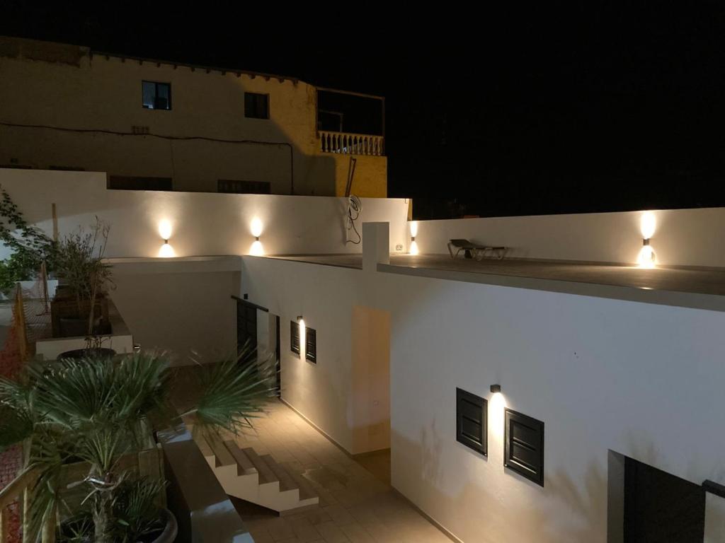 a white building with lights on the side of it at Casa Monte y Mar in Morro del Jable