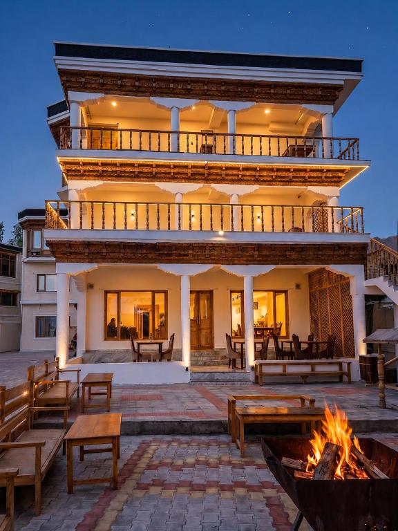 a building with a fire pit in front of it at Hotel Karakoram in Leh