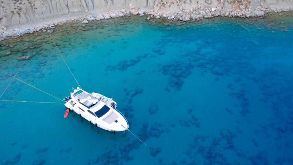 a white boat floating in the blue water at The Duke Superyacht - LINDIAN in Lindos