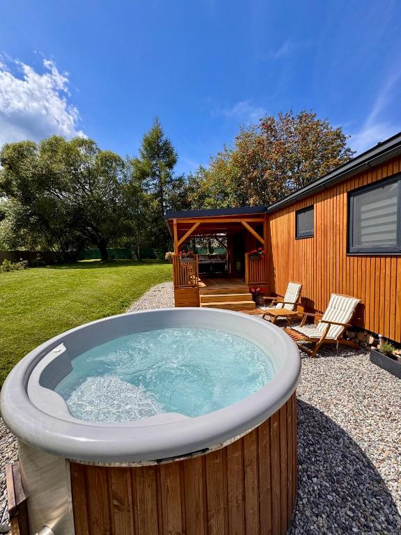 a hot tub in a yard next to a house at Domček pod Vežami s vírivkou a grilom, pri termálnom kúpalisku in Liptovský Ján