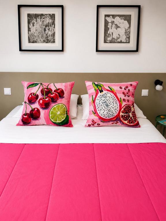 a bed with pink pillows and fruit on it at Aveiro Ria View in Aveiro