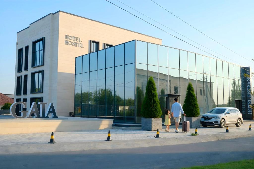 a man and a child standing in front of a building at Gaia in Türkistan