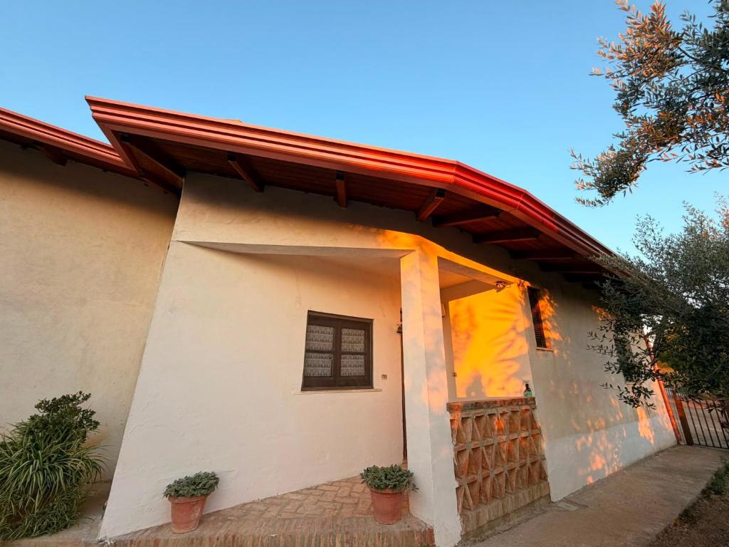 a small white house with a red roof at Agriturismo Siviglia in Tocci
