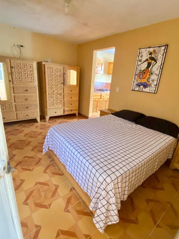 a bedroom with a bed with a checkered blanket at Accommodation near downtown in San Cristóbal de Las Casas