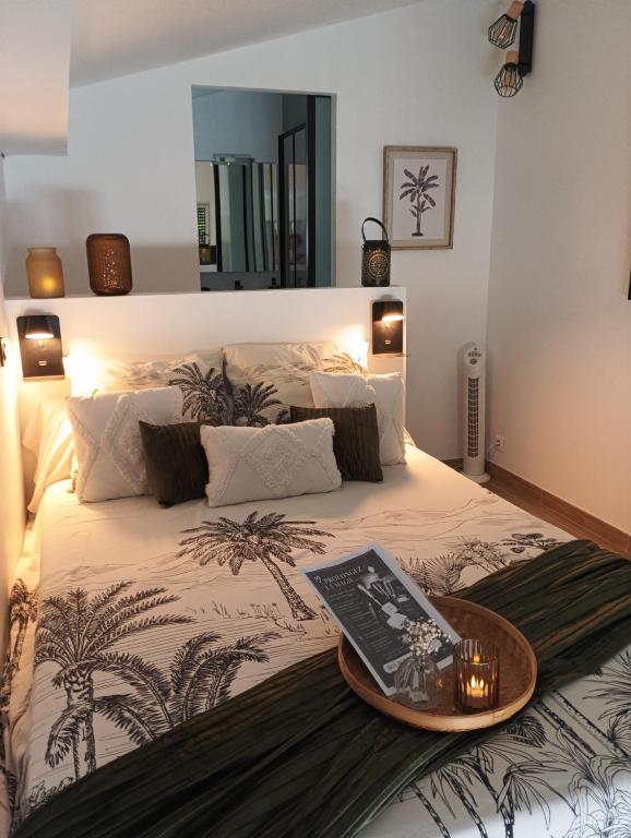 a bed with a tray with a book on it at L'Atelier Saint-Sulpice - Cocon, piscine, déconnexion entre Bordeaux et St Emilion in Saint-Sulpice-et-Cameyrac