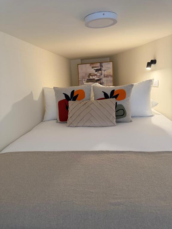a white bed with pillows on top of it at Tivat Cozy Studio in Tivat