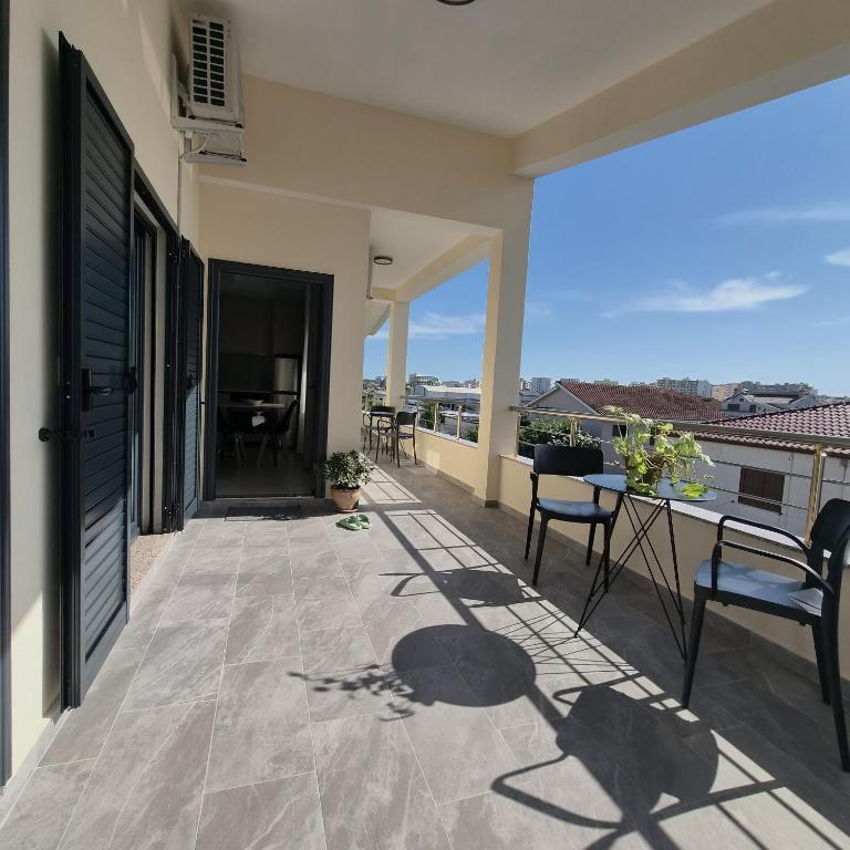 a balcony of a house with a table and chairs at Kypsel Apartment in Durrës