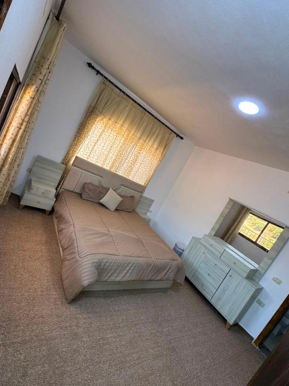 a bedroom with a large bed and a window at اطلالة سوف in Jerash