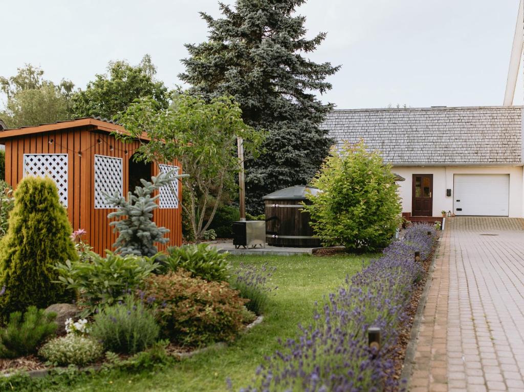 a garden in front of a house with a building at Lavandas apartamenti in Ikšķile