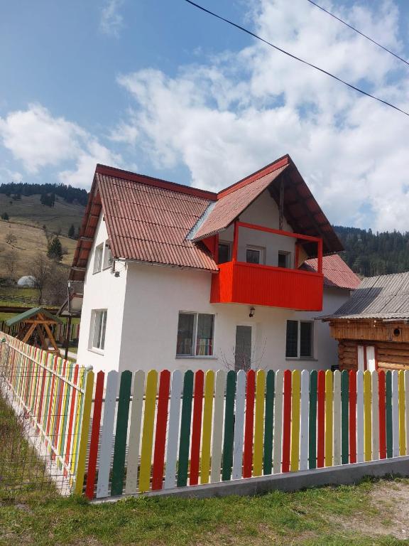 a house with a colorful fence in front of it at Casa Curcubeu in Ceahlău