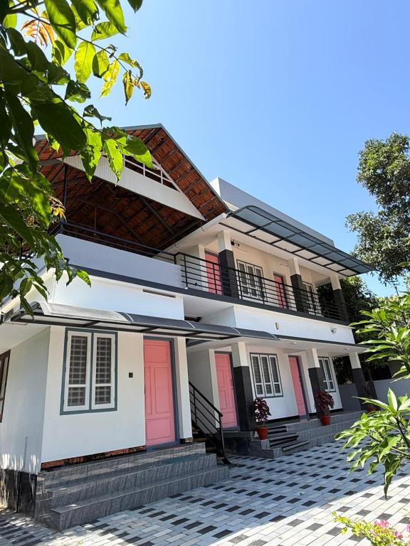 a house with red doors and a courtyard at Lakeside Meadows- Diamond Homestay in Kollam